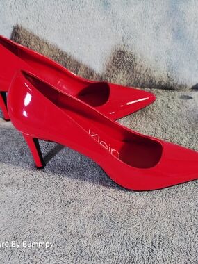 Calvin Klein pointed-toe kitten heel pumps in red patent leather.